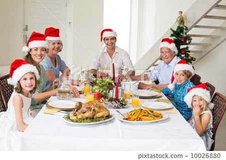 Happy family in Santa hats having Christmas meal 10026880