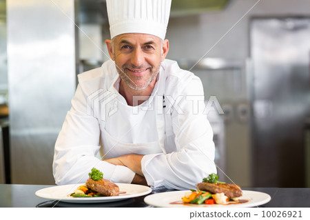 Confident male chef with cooked food in kitchen Confident male chef with cooked food in kitchen 10026921