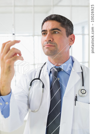 Serious male doctor holding an injection 10026925