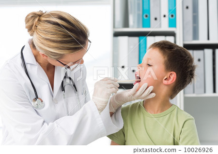 Doctor looking into the mouth of boy 10026926