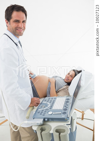 Doctor performing ultrasound on expectant woman 10027123