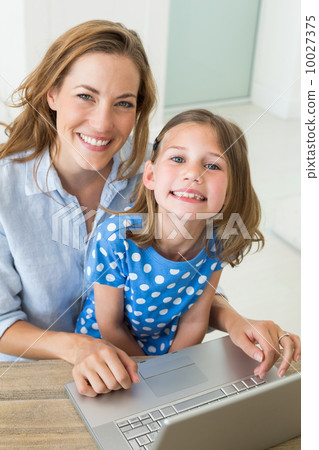 Happy girl with mother using laptop 10027375