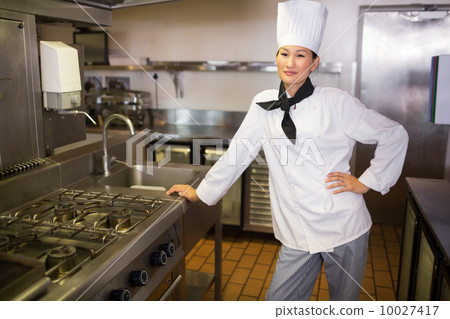 Smiling female cook in the kitchen Smiling female cook in the kitchen 10027417