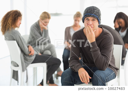 Upset man in rehab group looking at camera 10027483