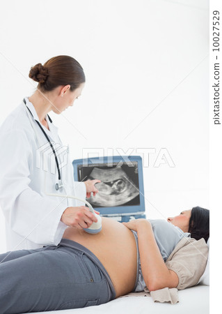 Doctor performing ultrasound on pregnant woman 10027529