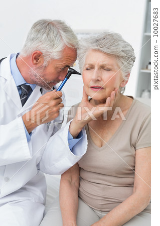 Male doctor examining senior patient's ear Male doctor examining senior patient's ear 10027683