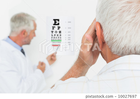 Pediatrician ophthalmologist with senior patient pointing at eye Pediatrician ophthalmologist with senior patient pointing at eye 10027697