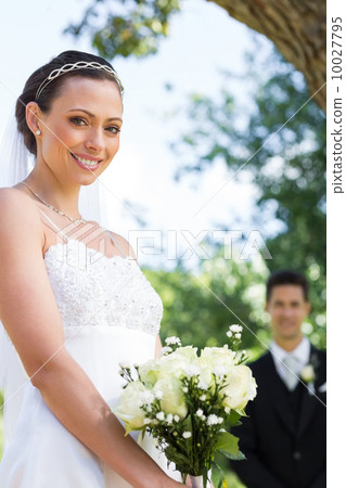Bride holding flower bouquet in garden 10027795