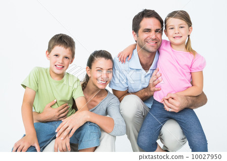 Cute family posing and smiling at camera together Cute family posing and smiling at camera together 10027950
