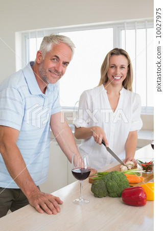 Cheerful couple making dinner together 10027975