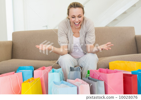 Excited woman looking at many shopping bags 10028076