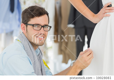 Male fashion designer adjusting dress on model Male fashion designer adjusting dress on model 10028081
