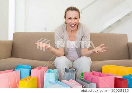 Excited woman looking at camera with many shopping bags 10028113
