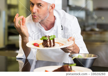 Smiling male pastry chef with dessert in kitchen 10028260