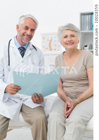 Male doctor and senior patient with reports Male doctor and senior patient with reports 10028359