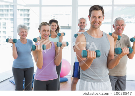 Class exercising with dumbbells in gym Class exercising with dumbbells in gym 10028847