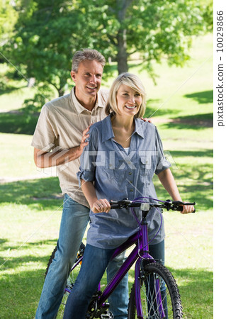 Couple riding bicycle in park 10029866