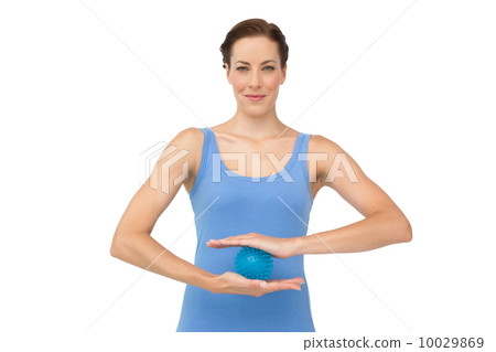 Portrait of a content young woman holding stress ball Portrait of a content young woman holding stress ball 10029869