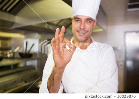 Male cook gesturing okay sign in kitchen Male cook gesturing okay sign in kitchen 10029870