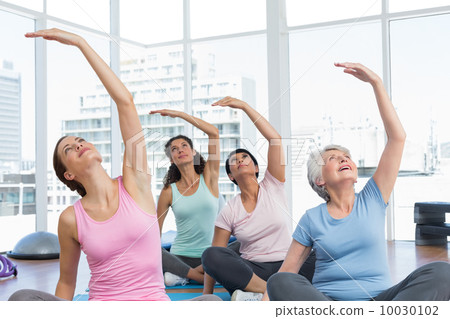 Class stretching hands at yoga class Class stretching hands at yoga class 10030102