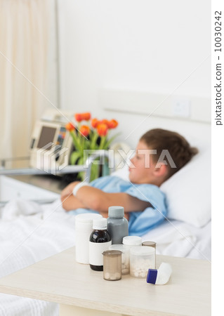 Medicines on table with boy in hospital 10030242