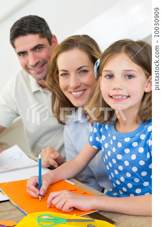 Girl drawing while sitting with parents Girl drawing while sitting with parents 10030909