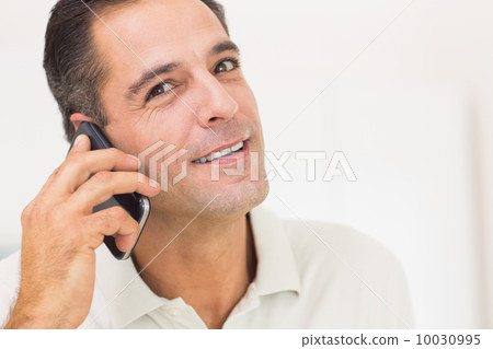 Closeup portrait of a smiling man using mobile phone 10030995
