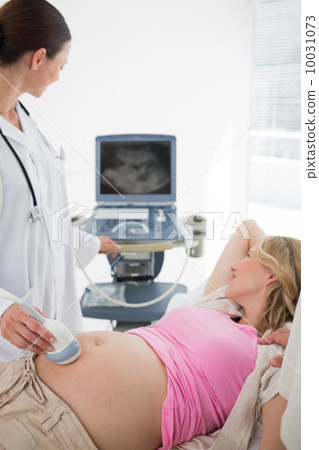 Doctor using ultrasound on pregnant woman Doctor using ultrasound on pregnant woman 10031073