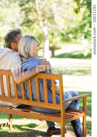Couple relaxing on park bench Couple relaxing on park bench 10031392