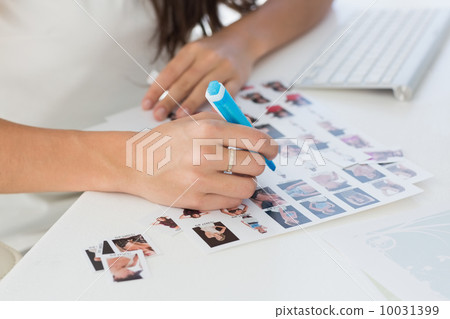 Editor working at her desk marking a contact sheet Editor working at her desk marking a contact sheet 10031399