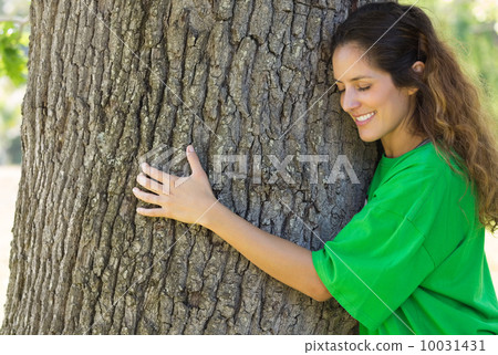 Environmentalist hugging tree trunk 10031431