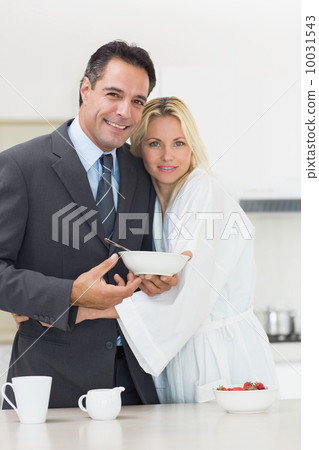 Portrait of a woman embracing well dressed man in kitchen Portrait of a woman embracing well dressed man in kitchen 10031543