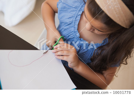 High angle close-up of a girl cutting chart paper 10031778