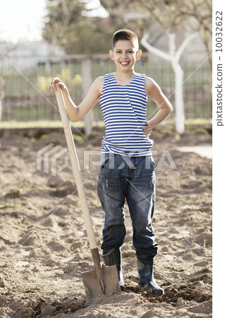 happy boy working with shovel in garden happy boy working with shovel in garden 10032622