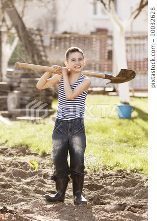 happy boy working with shovel in garden happy boy working with shovel in garden 10032628