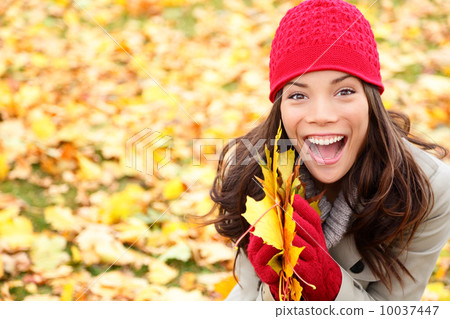 Asian Autumn woman holding fall leaves in forest Asian Autumn woman holding fall leaves in forest 10037447