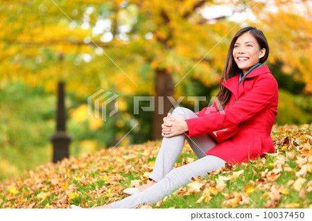 Fall woman relaxing happy in autumn forest foliage 10037450