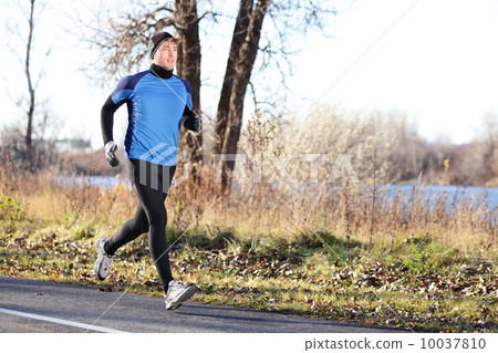 Male runner man running in autumn on cold day 10037810