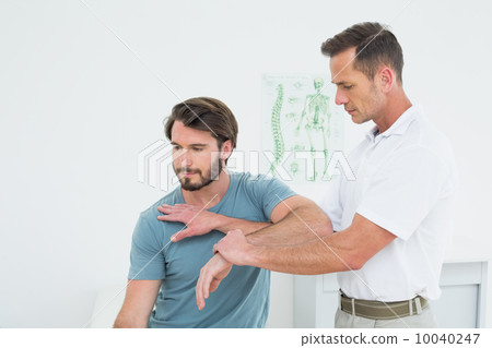 Male physiotherapist stretching a young man's hand Male physiotherapist stretching a young man's hand 10040247