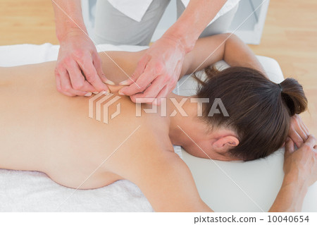 Male physiotherapist massaging woman's back 10040654