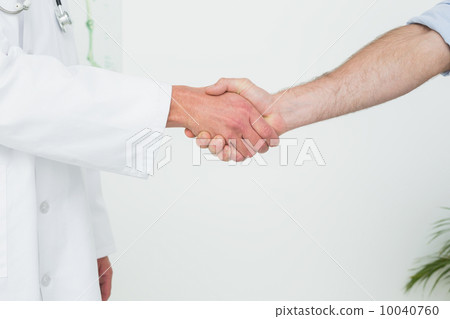 Close-up of a doctor and patient shaking hands 10040760