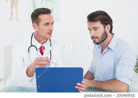 Doctor discussing reports with patient at medical office 10040958
