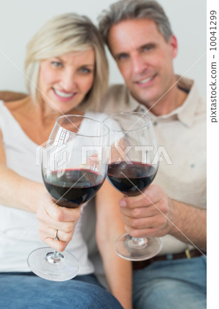 Happy couple holding out wine glasses 10041299