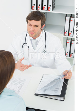 Doctor in conversation with female patient in medical office 10041302