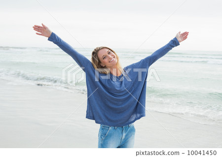 Happy woman with hands raised at beach Happy woman with hands raised at beach 10041450