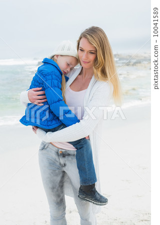 Woman carrying her little girl at beach 10041589