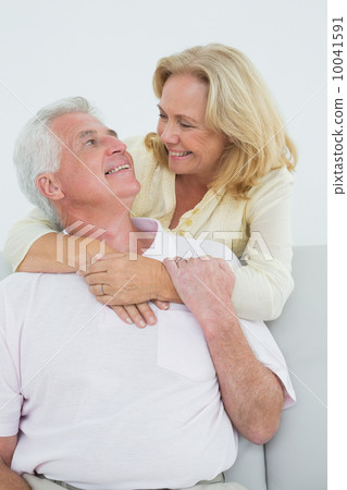 Happy senior woman embracing man from behind 10041591