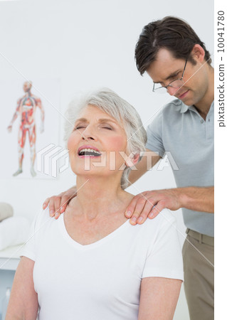 Male physiotherapist massaging a senior woman's shoulders Male physiotherapist massaging a senior woman's shoulders 10041780