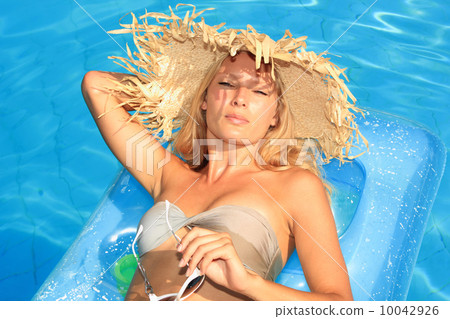 Young woman enjoying a swimming pool Young woman enjoying a swimming pool 10042926