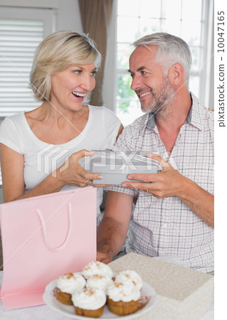 Mature man giving a gift box to happy woman Mature man giving a gift box to happy woman 10047165